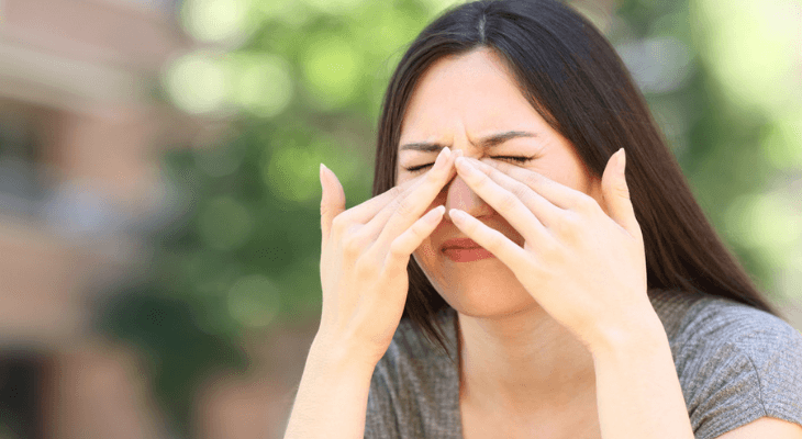 Woman rubbing her eyes in pain