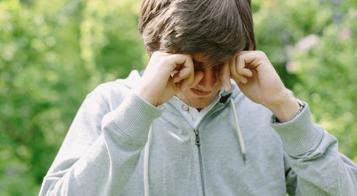 Young man rubbing his eyes