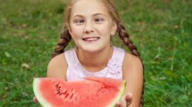 Girl crossed eyed holding a watermelon