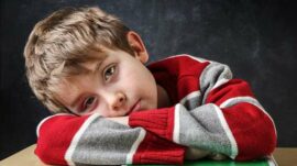 Boy with his head down on a desk