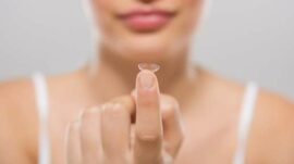 Women holding contact lens on a finger tip