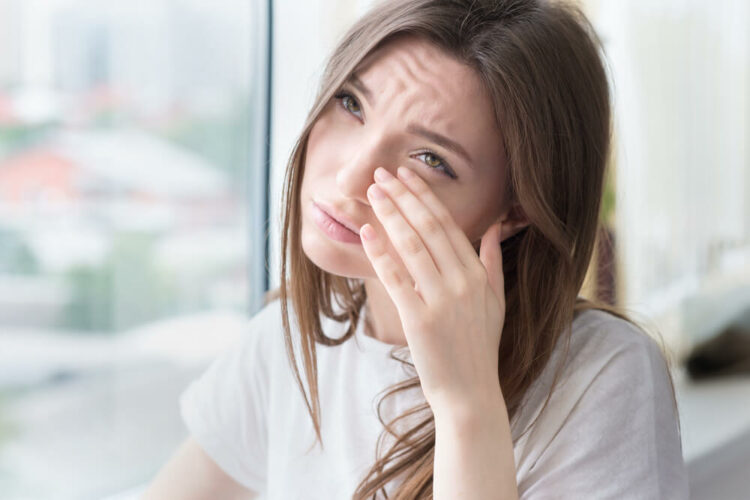 Woman rubbing her eye in pain