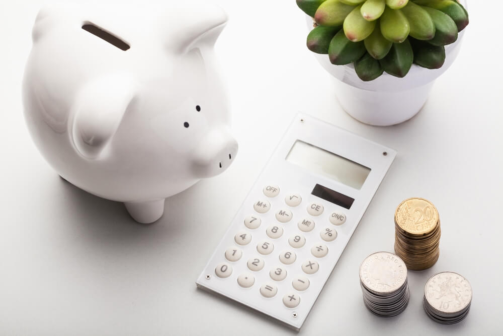 Piggy bank, calculator and coins