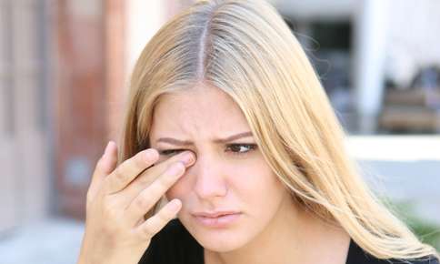 Woman rubbing her irritated eyes