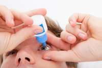 Man putting in eye drops