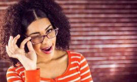 Woman tipping glasses and winking