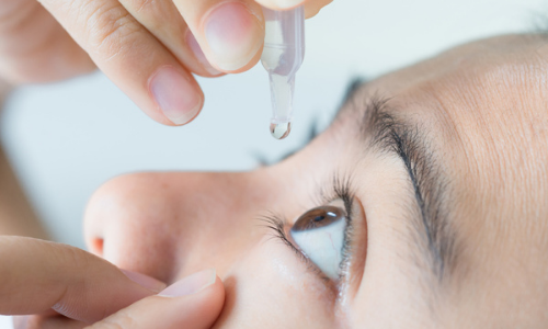 Woman using eye drops